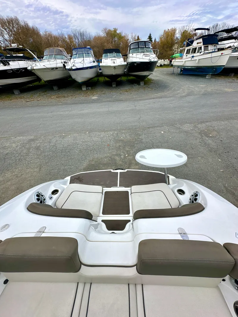 Slide: The Image of 2012 Yamaha Boats 242 Limited S, docked with other boats, featuring spacious seating and table. - 4