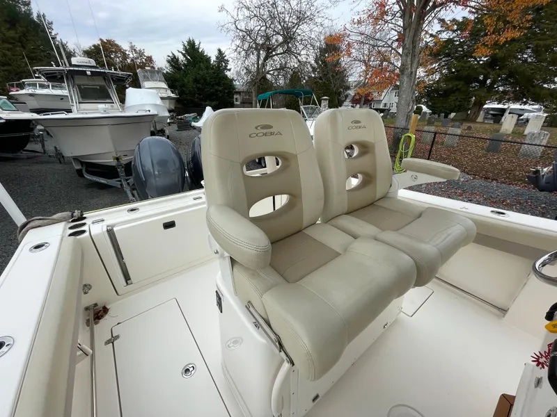 Slide: The Image of 2018 Cobia 261 boat with beige seating, docked outdoors. - 11