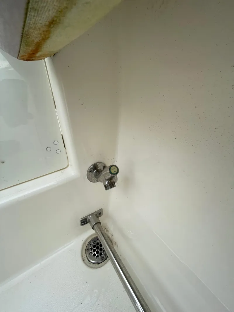 Slide: The Image of 2018 Cobia 261 boat interior with drain and valve detail. - 16