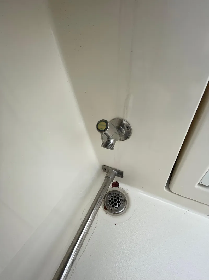 Slide: The Image of 2018 Cobia 261 boat interior with drain and valve detail. - 17