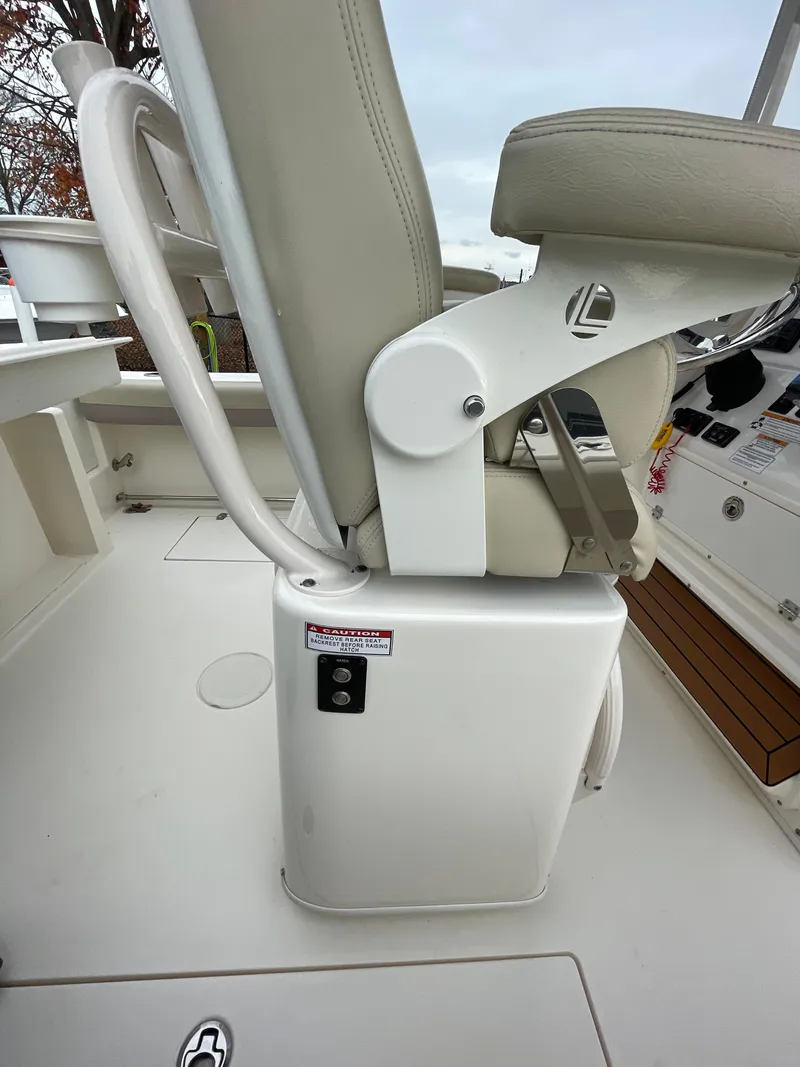 Slide: The Image of 2018 Cobia 261 boat seat and console detail, featuring white and beige upholstery. - 19