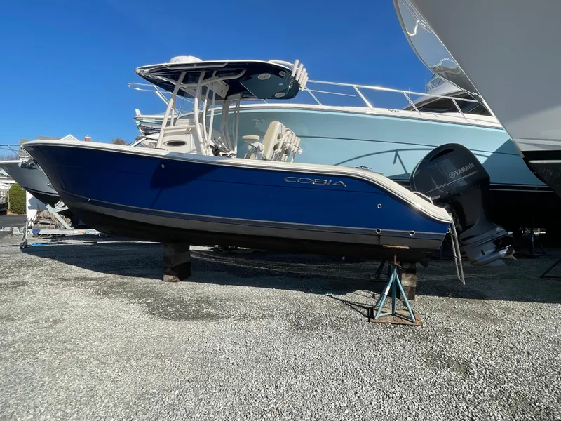 Slide: The Image of 2018 Cobia 261 boat with blue hull on dry dock. - 2