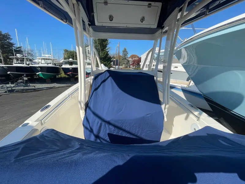 Slide: The Image of 2018 Cobia 261 boat with blue covers, docked among other boats. - 21