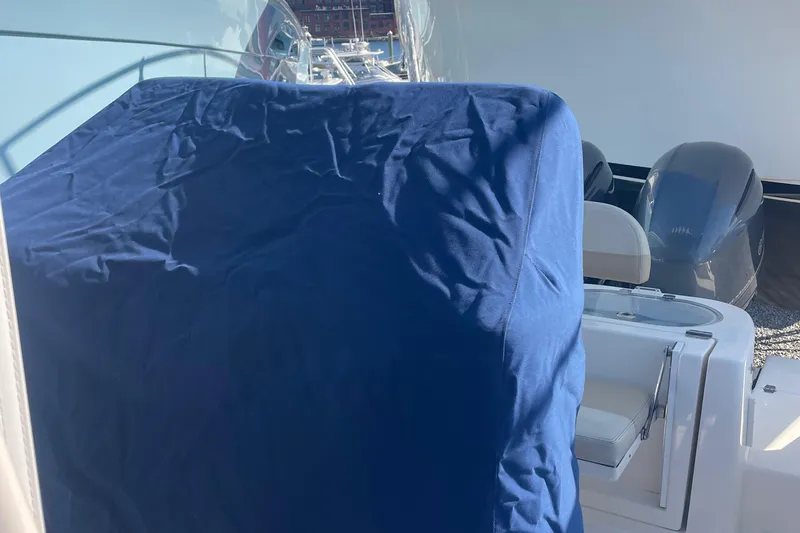 Slide: The Image of 2018 Cobia 261 boat with blue cover and dual engines. - 23