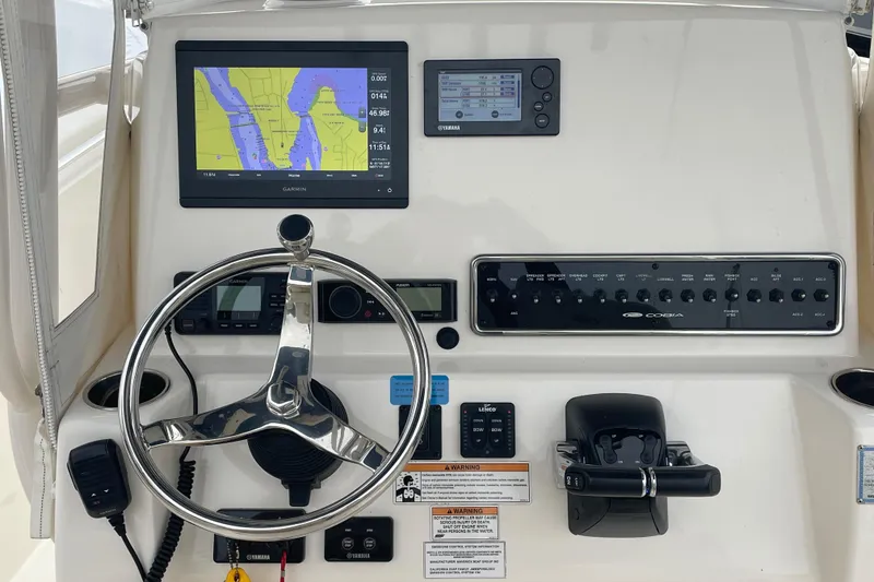 Slide: The Image of 2018 Cobia 261 boat dashboard with navigation screens and steering wheel. - 4