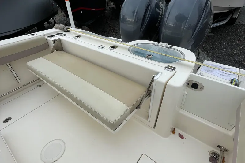 Slide: The Image of 2018 Cobia 261 boat interior with foldable bench seat and dual outboard motors. - 9