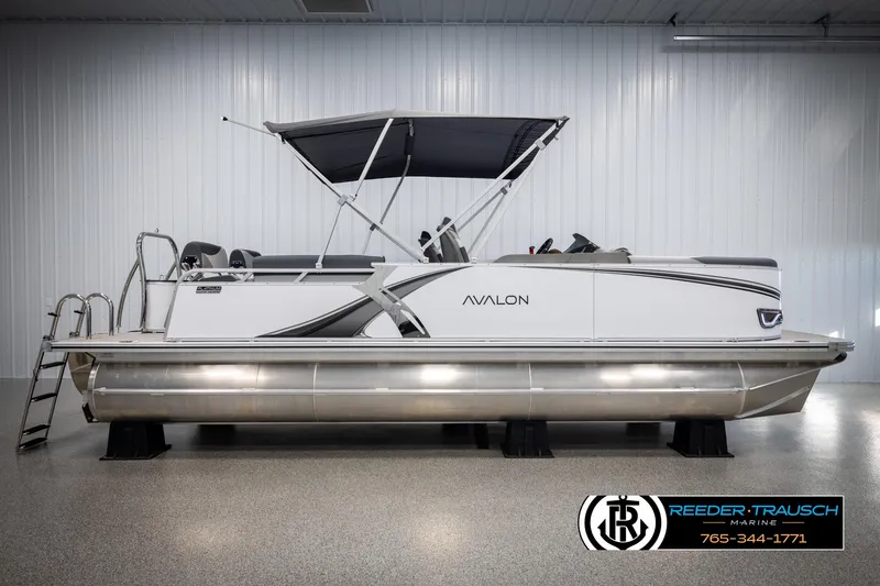 Slide: The Image of 2025 Avalon LSZ QLS pontoon boat in showroom, featuring sleek design and canopy. - 5