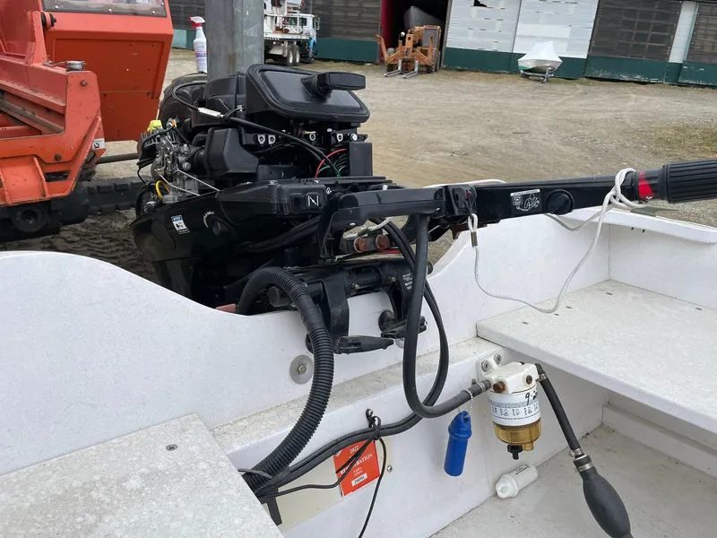 Slide: The Image of 2017 Rossiter Estate Skiff with outboard motor, docked on a gravel surface. - 9