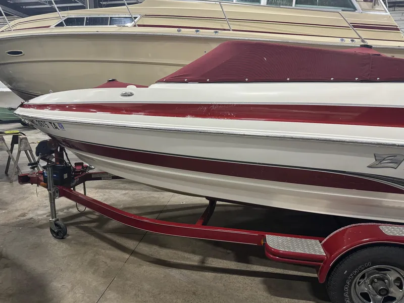 Slide: The Image of 2007 Larson LXi 208 boat with red and white design on trailer in storage. - 2