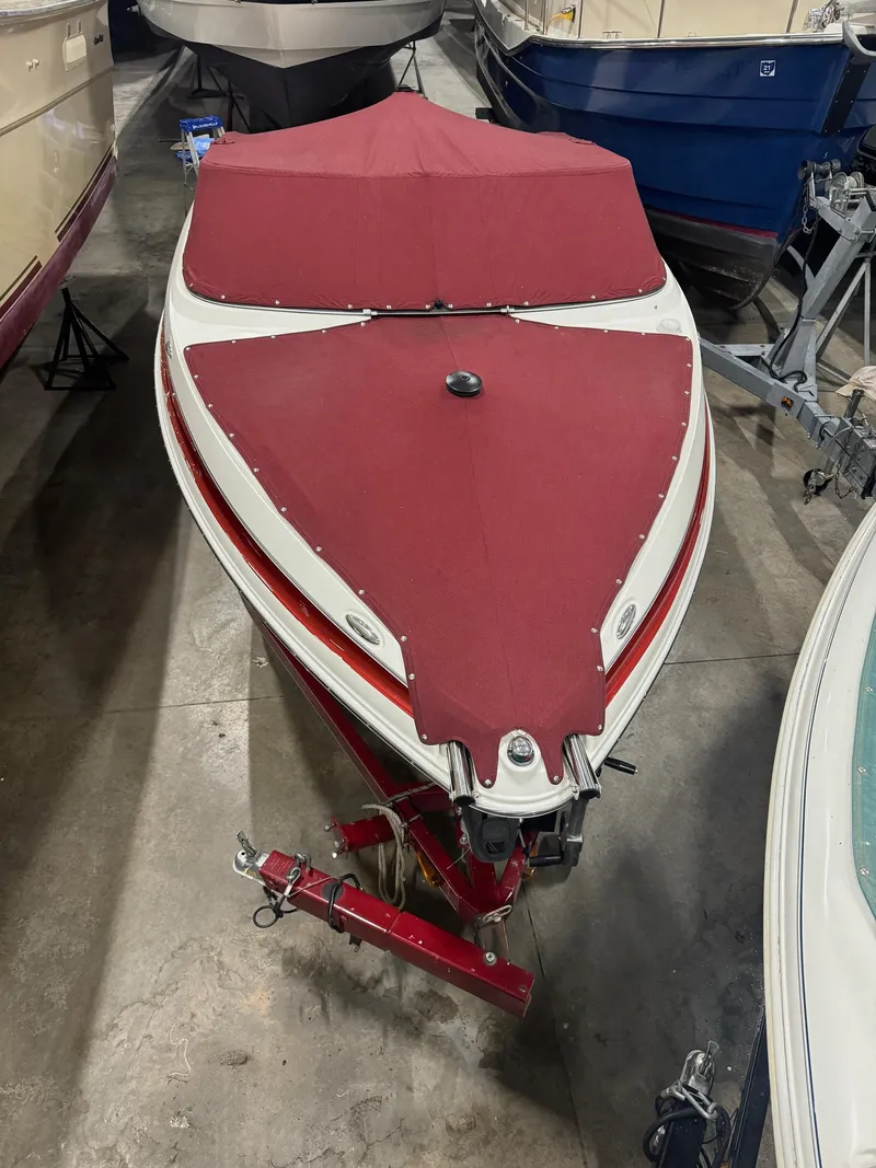 Slide: The Image of 2007 Larson LXi 208 boat with red cover in storage. - 3