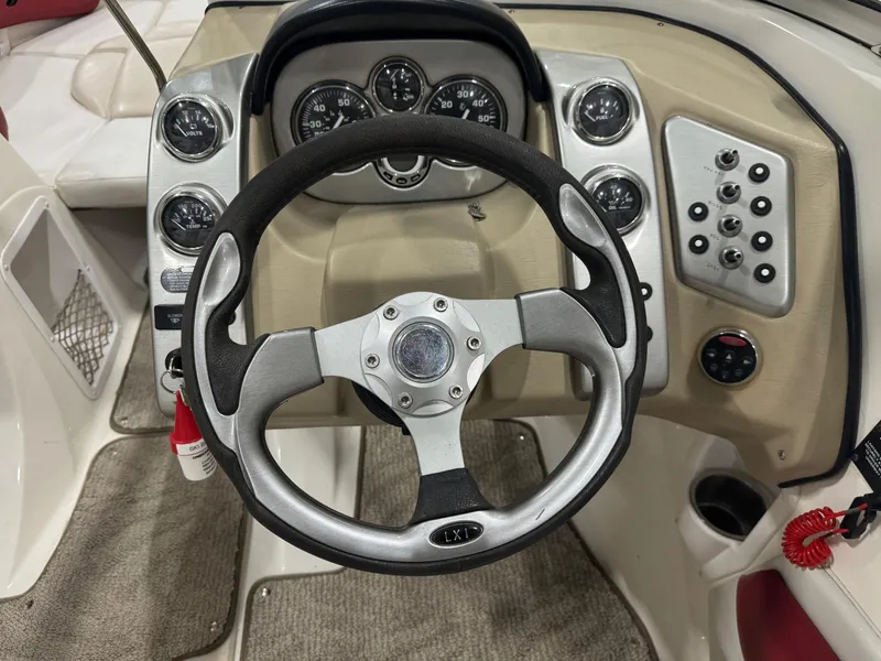 Slide: The Image of 2007 Larson LXi 208 boat dashboard with steering wheel and control panel. - 7