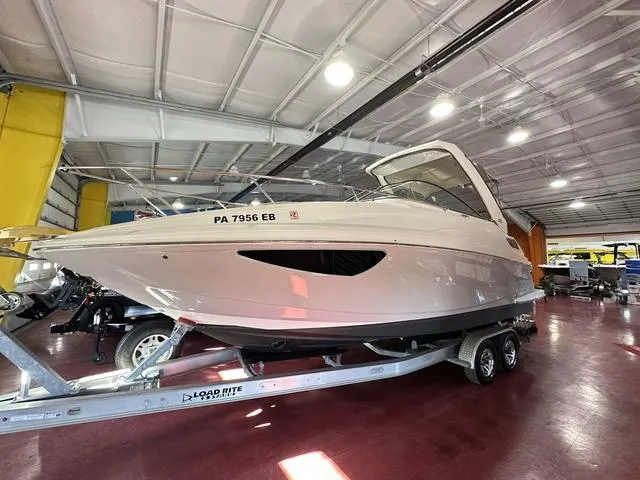 Slide: The Image of 2022 Regal 28 Express boat on trailer in indoor showroom. - 1