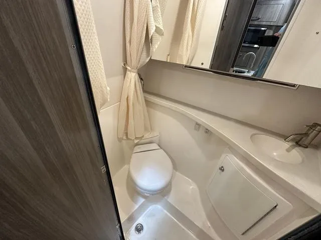 Slide: The Image of 2022 Regal 28 Express boat bathroom with shower, toilet, and sink. - 11