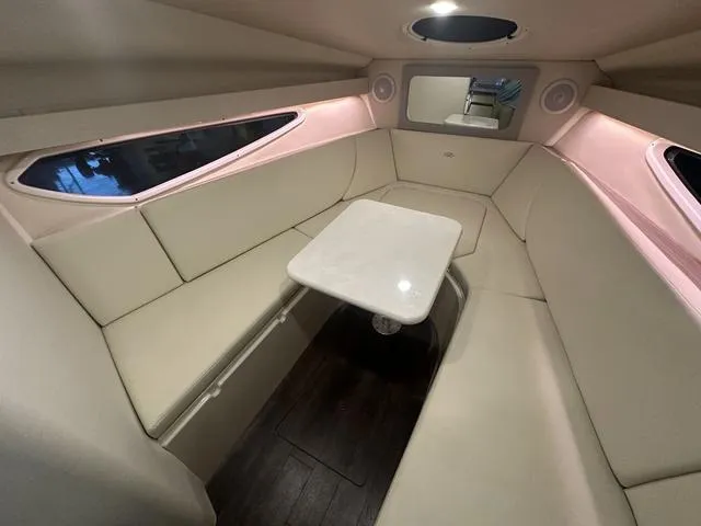 Slide: The Image of 2022 Regal 28 Express cabin interior with beige seating and a central table. - 26