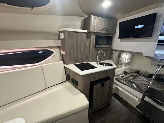 Slide: The Image of 2022 Regal 28 Express cabin interior with kitchenette, seating, and TV. - 28