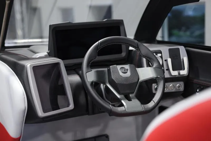 Slide: The Image of 2024 Malibu 24 MXZ boat dashboard with modern steering wheel and digital displays. - 13