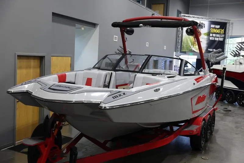 Slide: The Image of 2024 Malibu 24 MXZ boat on red trailer in showroom. - 7