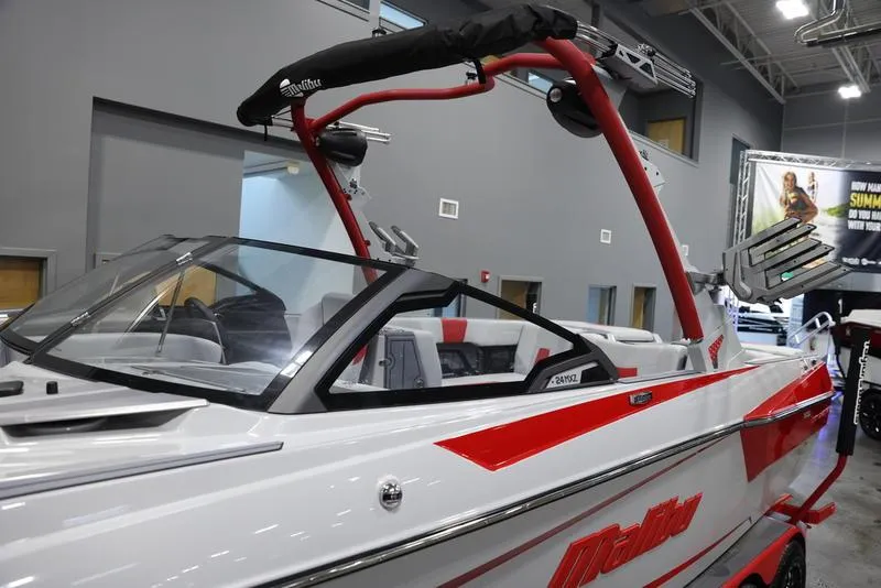 Slide: The Image of 2024 Malibu 24 MXZ boat with red accents displayed indoors. - 8