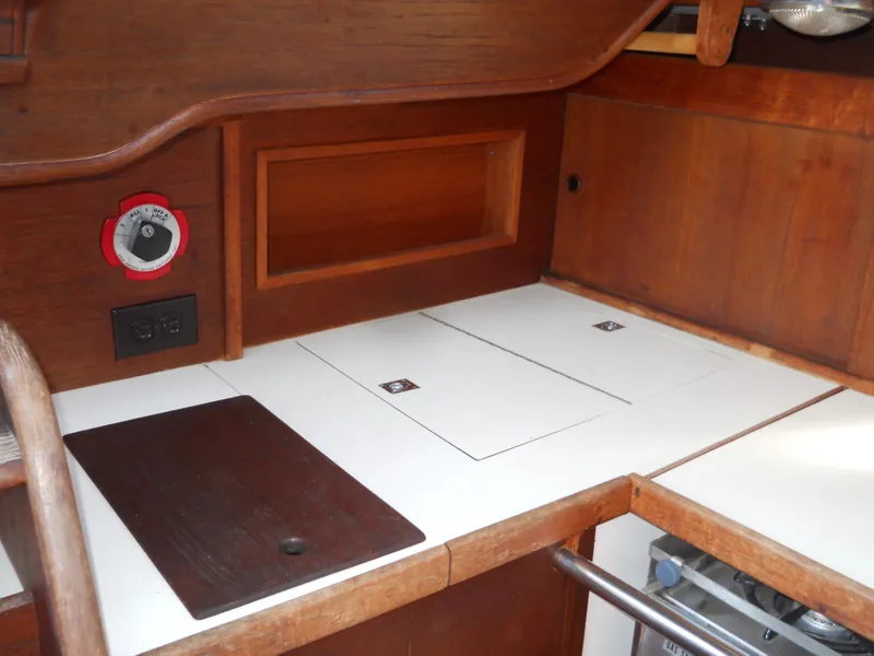 Slide: The Image of 1985 Sabre 38 MK I yacht interior with wooden cabinetry and white countertops. - 11