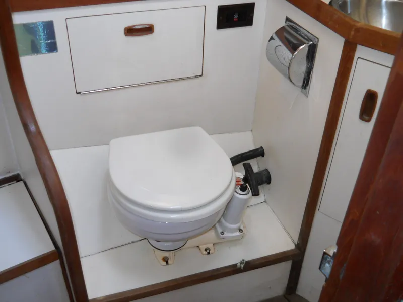 Slide: The Image of 1985 Sabre 38 MK I yacht bathroom with marine toilet and wooden accents. - 17