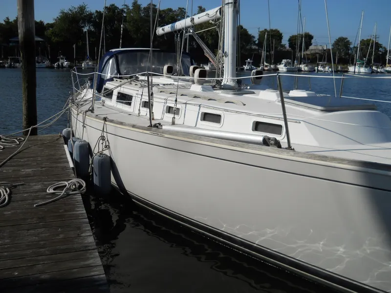 Slide: The Image of 1985 Sabre 38 MK I sailboat docked at a marina, surrounded by calm water. - 3
