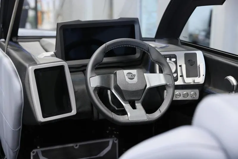 Slide: The Image of 2024 Malibu 23 LSV boat dashboard with modern steering and digital displays. - 16