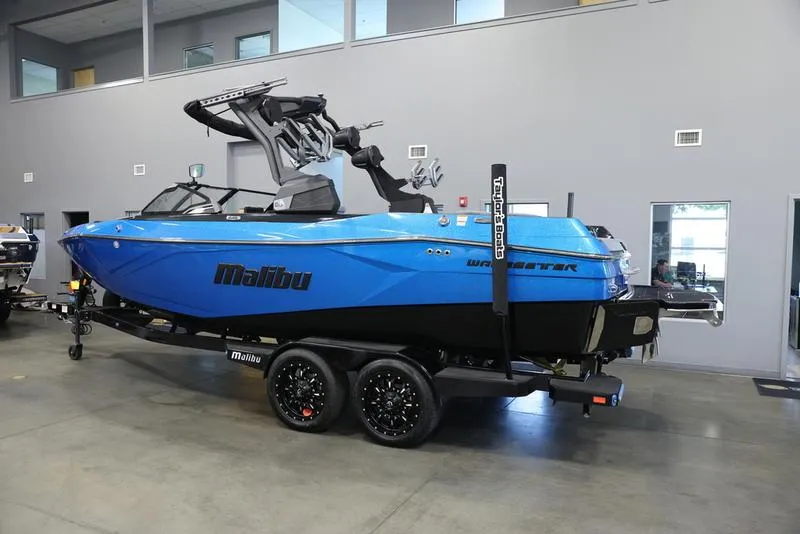 Slide: The Image of 2024 Malibu 23 LSV boat in showroom, blue exterior, on trailer. - 5