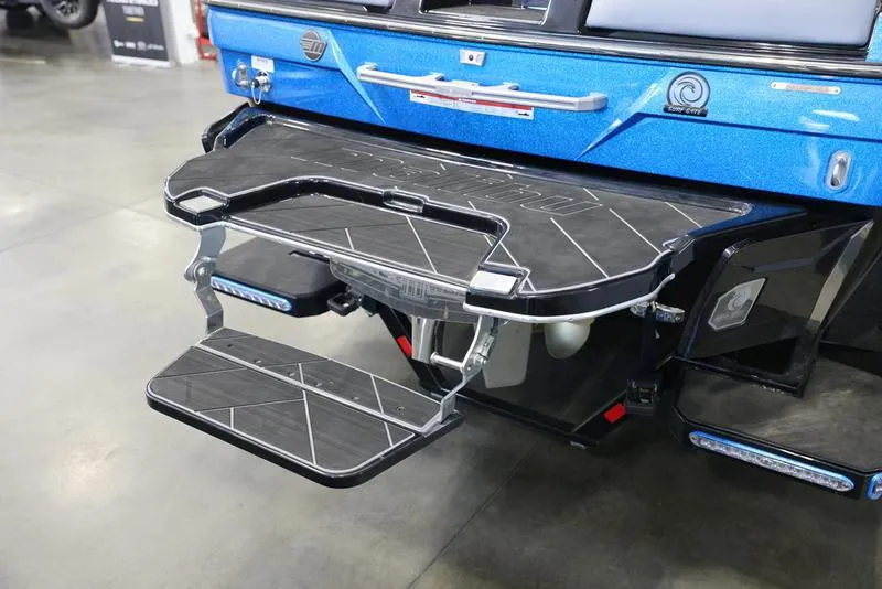 Slide: The Image of 2024 Malibu 23 LSV boat swim platform with foldable step, showcased indoors. - 6