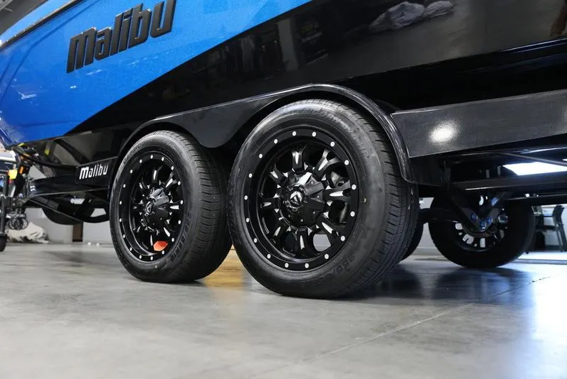 Slide: The Image of 2024 Malibu 23 LSV boat trailer with black wheels in a garage. - 8
