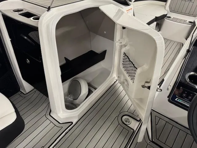 Slide: The Image of 2025 Yamaha Boats 252SD interior storage compartment with open door, showcasing sleek design. - 10
