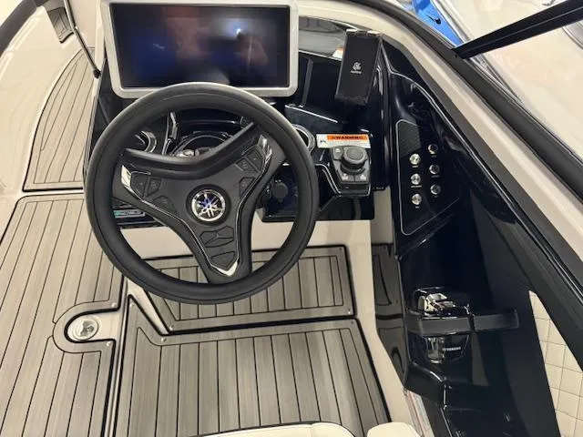 Slide: The Image of 2025 Yamaha Boats 252SD helm with steering wheel and touchscreen display. - 6