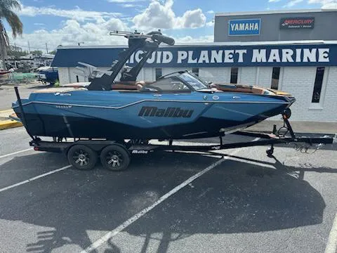 Slide: The Image of 2025 Malibu M230 boat swim platform with step, parked on pavement. - 1