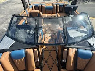 Slide: The Image of 2025 Malibu M230 boat interior with tan and blue leather seating. - 17