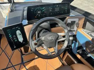 Slide: The Image of 2025 Malibu M230 boat dashboard with modern digital displays and steering wheel. - 31