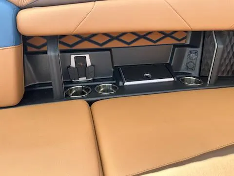 Slide: The Image of 2025 Malibu M230 interior with tan leather seats and cup holders. - 32