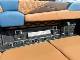 Slide: The Image of 2025 Malibu M230 boat interior with stylish seating and cup holders. - 34