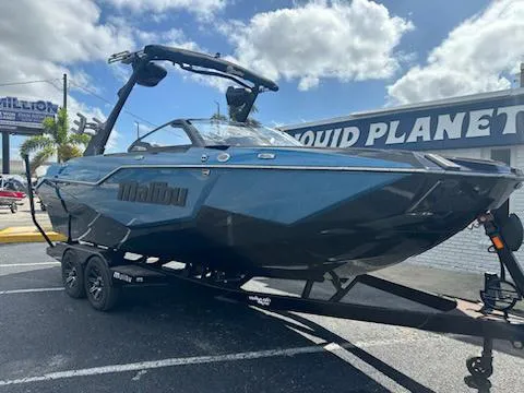 Slide: The Image of 2025 Malibu M230 boat interior with tan and blue upholstery, diamond stitching. - 4