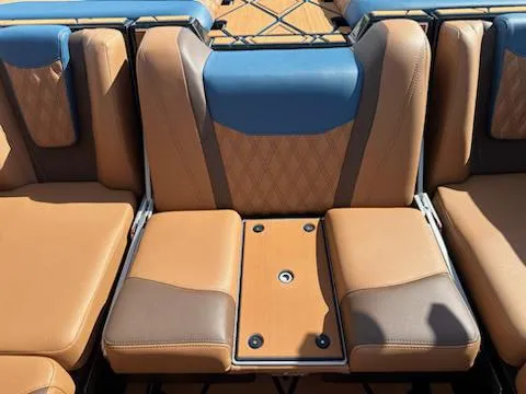 Slide: The Image of 2025 Malibu M230 boat interior with tan and blue seating. - 43