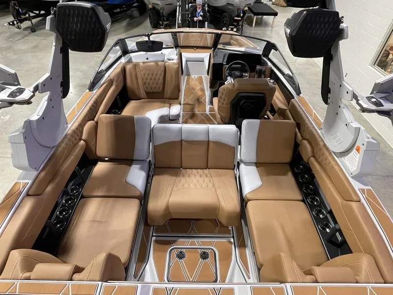 Slide: The Image of 2025 Malibu M230 boat interior with luxurious tan seating and modern design. - 14