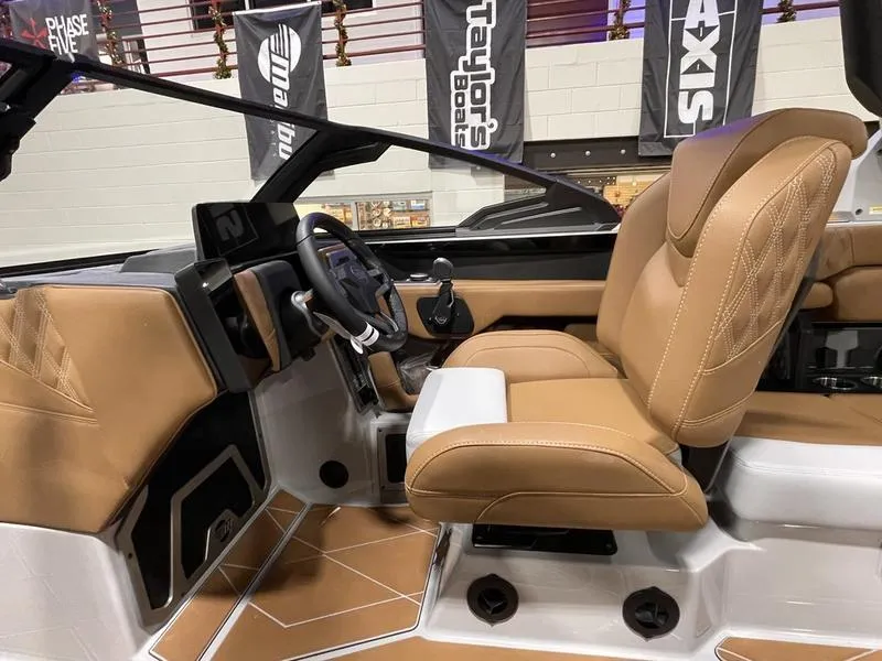Slide: The Image of 2025 Malibu M230 boat interior with tan leather seats and modern dashboard. - 20