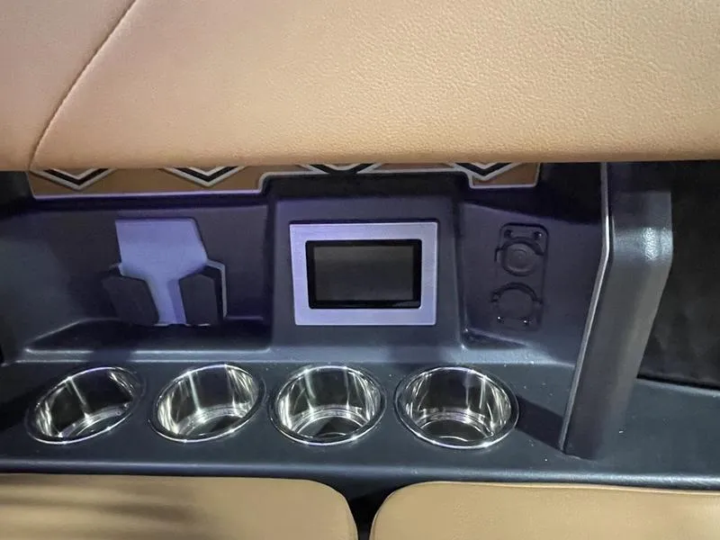Slide: The Image of Interior of 2025 Malibu M230 with cup holders and control panel. - 23