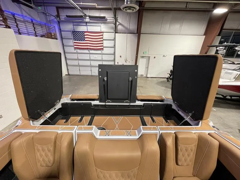 Slide: The Image of 2025 Malibu M230 boat interior with tan leather seats in a garage setting. - 28