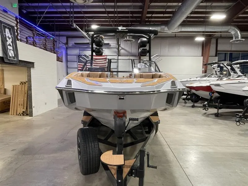 Slide: The Image of 2025 Malibu M230 boat in showroom, front view, on trailer. - 5