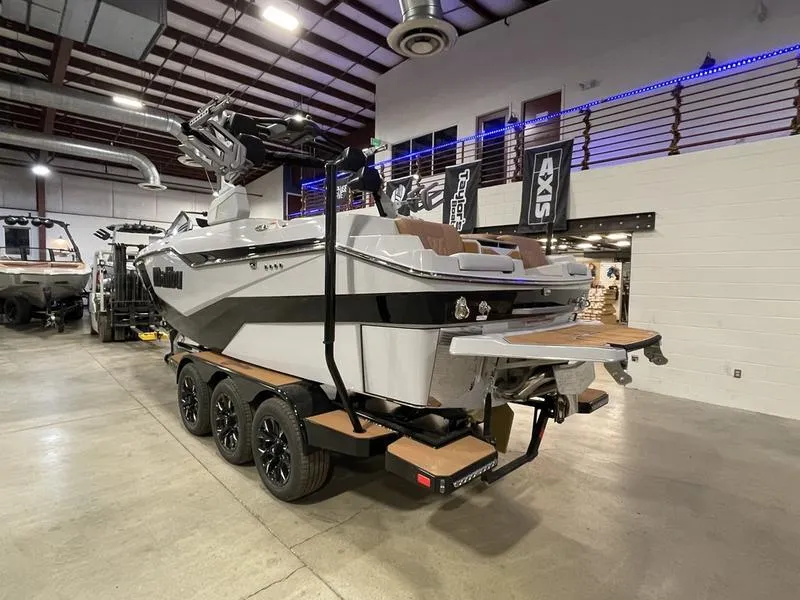 Slide: The Image of 2025 Malibu M230 boat in showroom, featuring sleek design and modern amenities. - 9