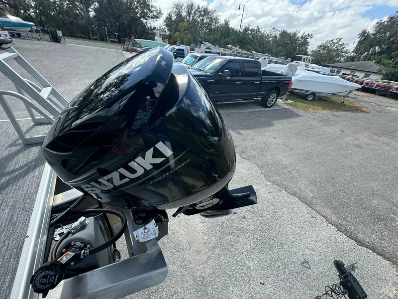 Slide: The Image of Suzuki outboard motor on Sweetwater 1886 CX boat, 2025 model, in a parking lot. - 9