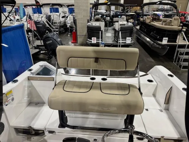 Slide: The Image of 2025 Yamaha Boats 222 FSH Sport E interior with beige seating at a boat show. - 15
