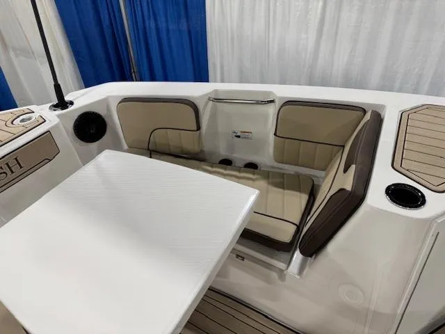 Slide: The Image of 2025 Yamaha Boats 222 FSH Sport E interior seating with table, beige upholstery, and cup holders. - 4