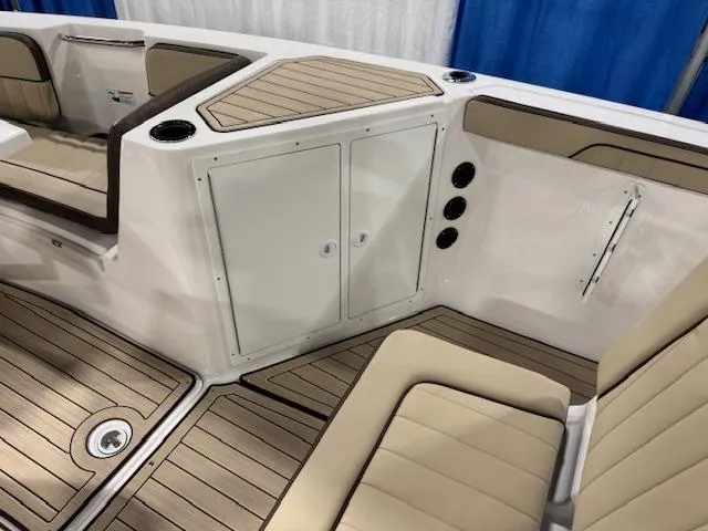 Slide: The Image of 2025 Yamaha Boats 222 FSH Sport E interior with beige seating and wood accents. - 9