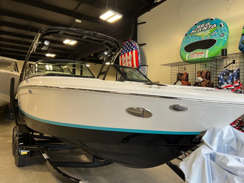 Slide: The Image of 2025 Regal LS2 Surf boat in showroom, featuring sleek design and modern accessories. - 12