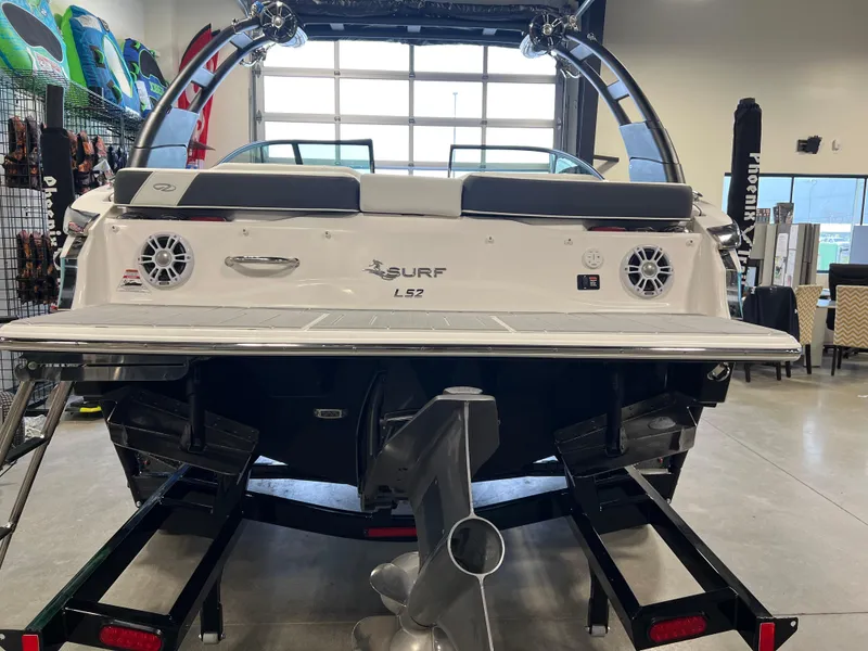 Slide: The Image of 2025 Regal LS2 Surf boat in showroom, rear view with trailer. - 2